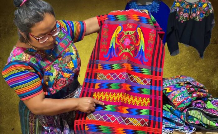 "Vibrant Maya weaver showcasing traditional artistry - Embark on a cultural immersion in Guatemala, the ultimate destination to experience the rich heritage of Maya textiles."