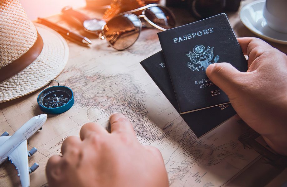 ravel advisor expert in Guatemala and Belize, holding passports in one hand while pointing at a map on the table, specializing in personalized travel itineraries.