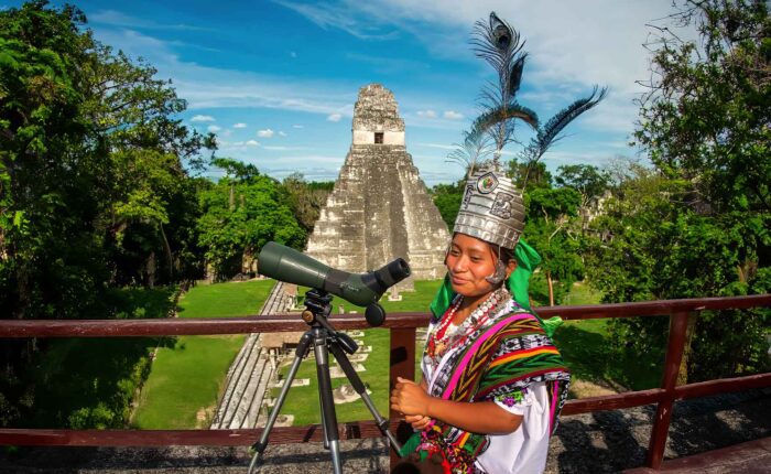 Guatemala-ancient-ruins-maya-legacy: the picture perfectly combine the past and present of the Maya. A Maya queen and Tikal temple in the background.