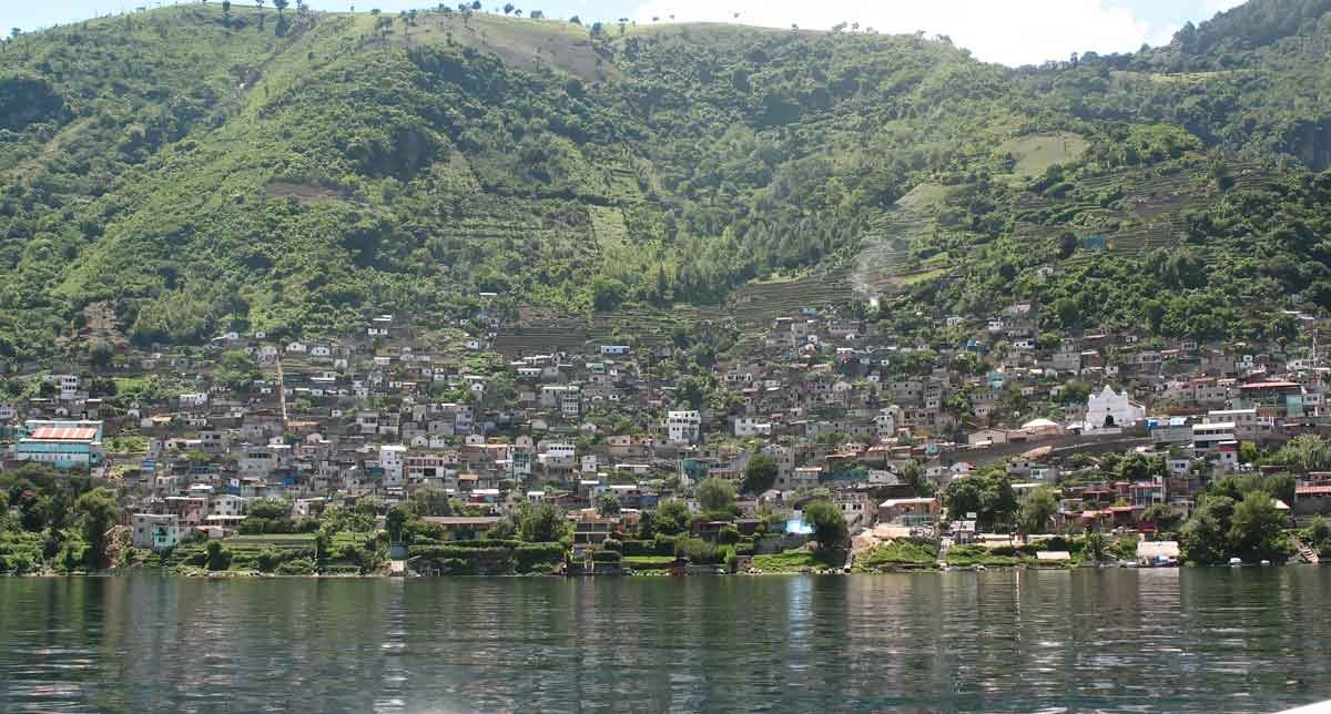Colorful hillside homes of Santa Catarina Palopó by Lake Atitlan, with traditional patterns and calm waters under a clear highland sky.