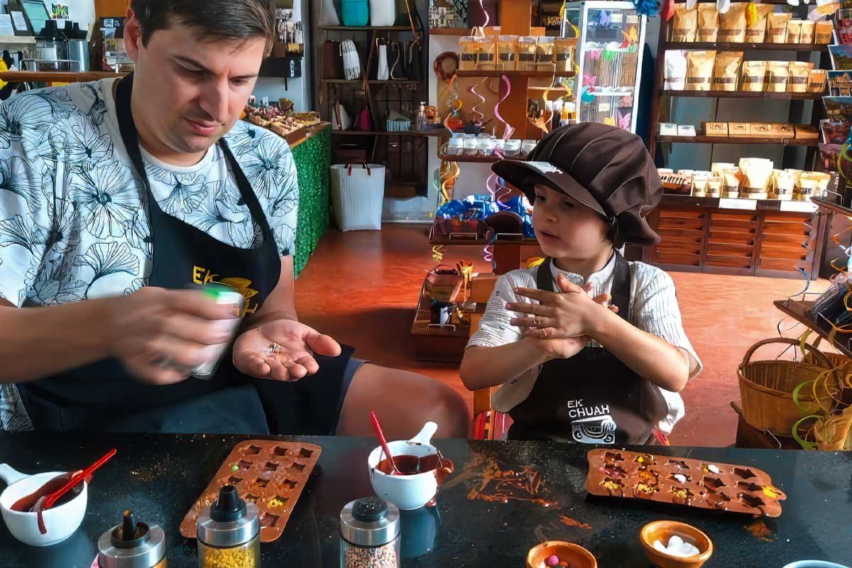 Father and young daughter enjoying a hands-on chocolate workshop in Antigua Guatemala, part of a family-friendly travel package to Guatemala.