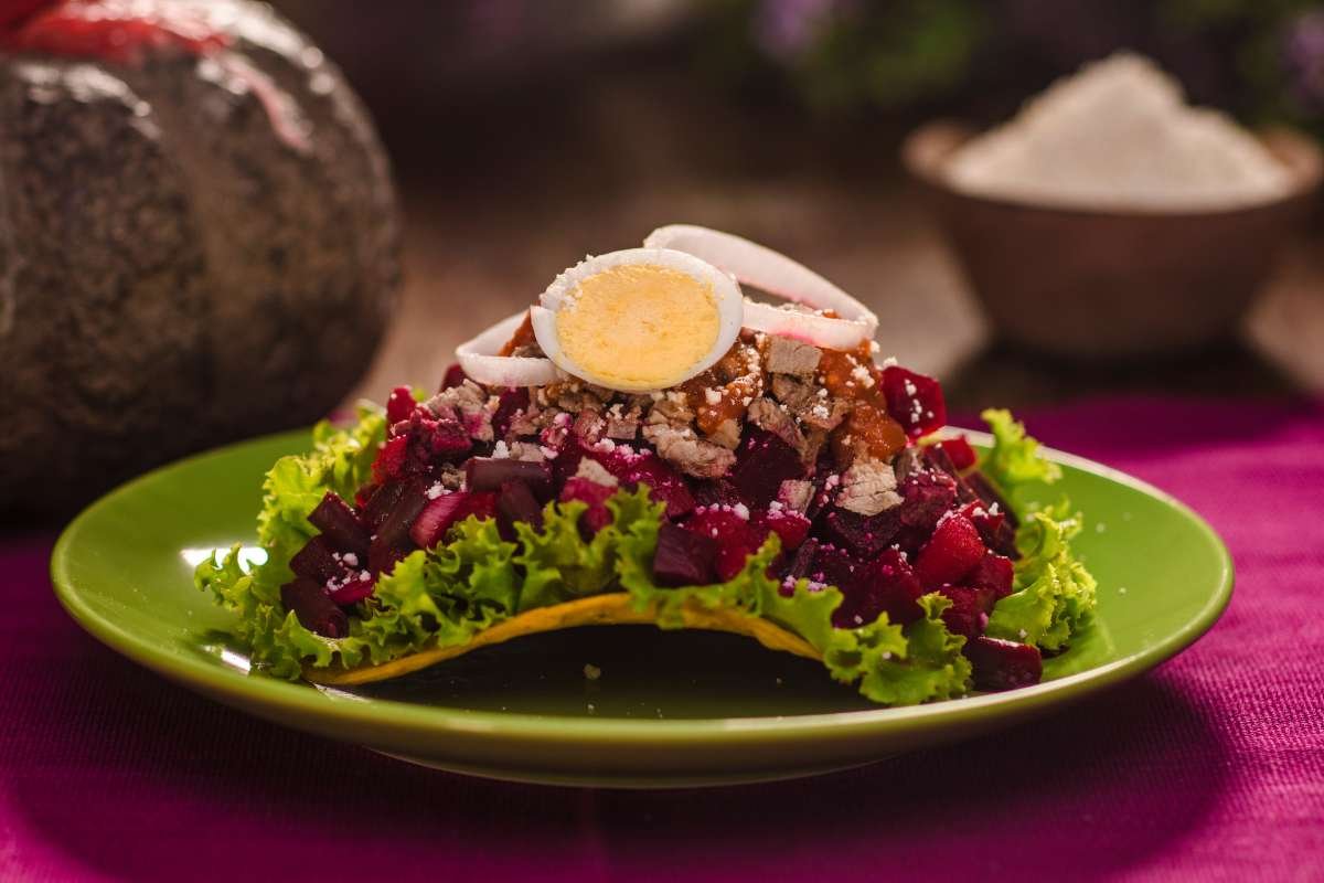 Traditional Guatemalan tostada topped with beet (betabel), sliced eggs, and fresh vegetables – a colorful example of Guatemalan street food.