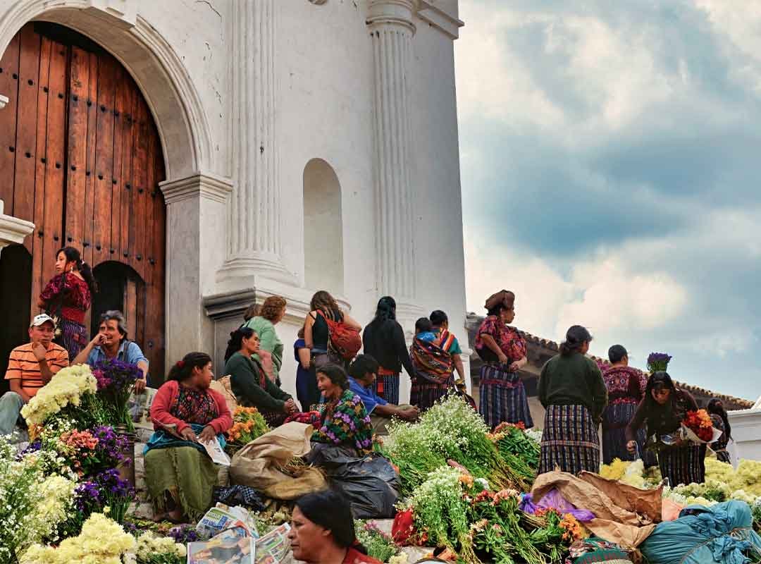 Chichi | martsam Chichicastenango Fair at Santo Tomás Church entrance with visitors and flower vendors