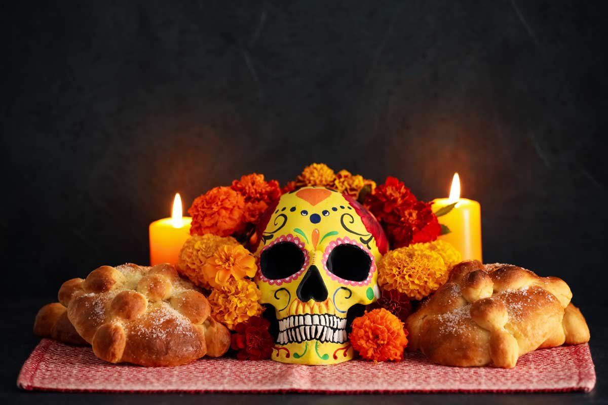 Day of the Dead altar with food offerings, marigolds, and decorated skulls in Mexico, part of the November festivals in the Mayan World