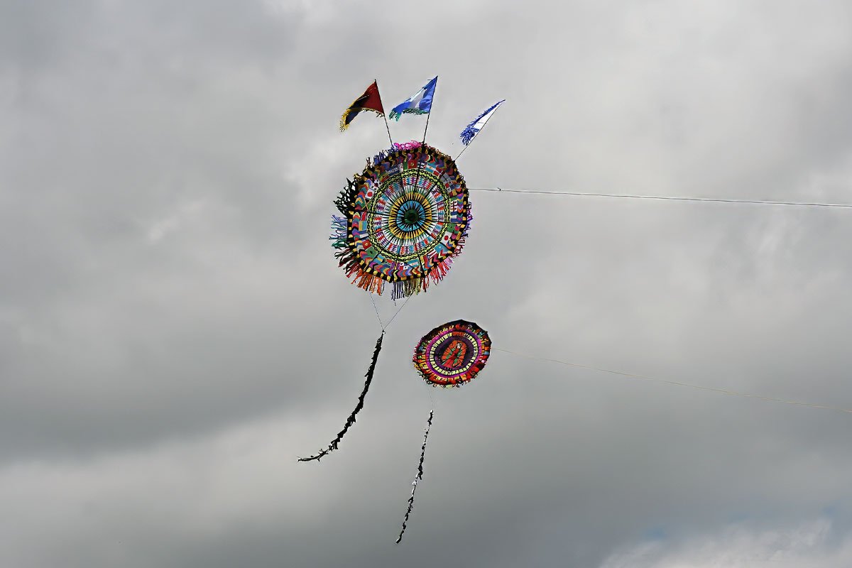 Two small colorful kites flying during the November festivals in the Mayan World, symbolizing ancestral connection.
