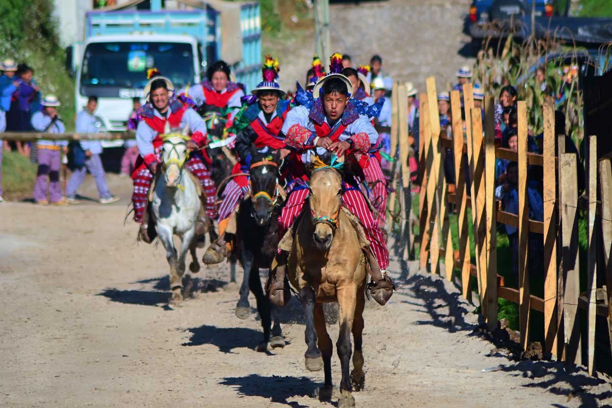 Group of riders in traditional Mayan clothing during the Skach Koyl horse race, part of the November festivals in the Mayan World.