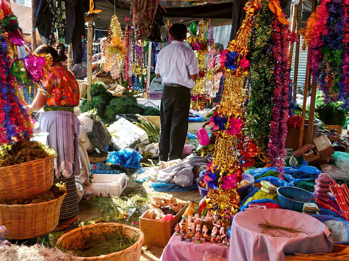 Colorful Christmas decorations and handcrafted ornaments displayed in a festive Guatemalan market, showcasing the vibrant culture of Guatemala in December.