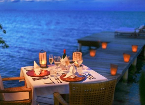 Elegant luxury dinner setting overlooking Lake Atitlán at sunset, included in our custom luxury Guatemala vacation packages.