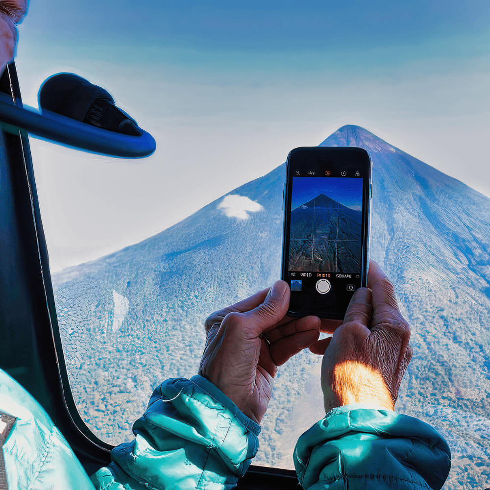 Traveler capturing a photo of Fuego Volcano from a helicopter, part of our exclusive luxury Guatemala vacation packages.