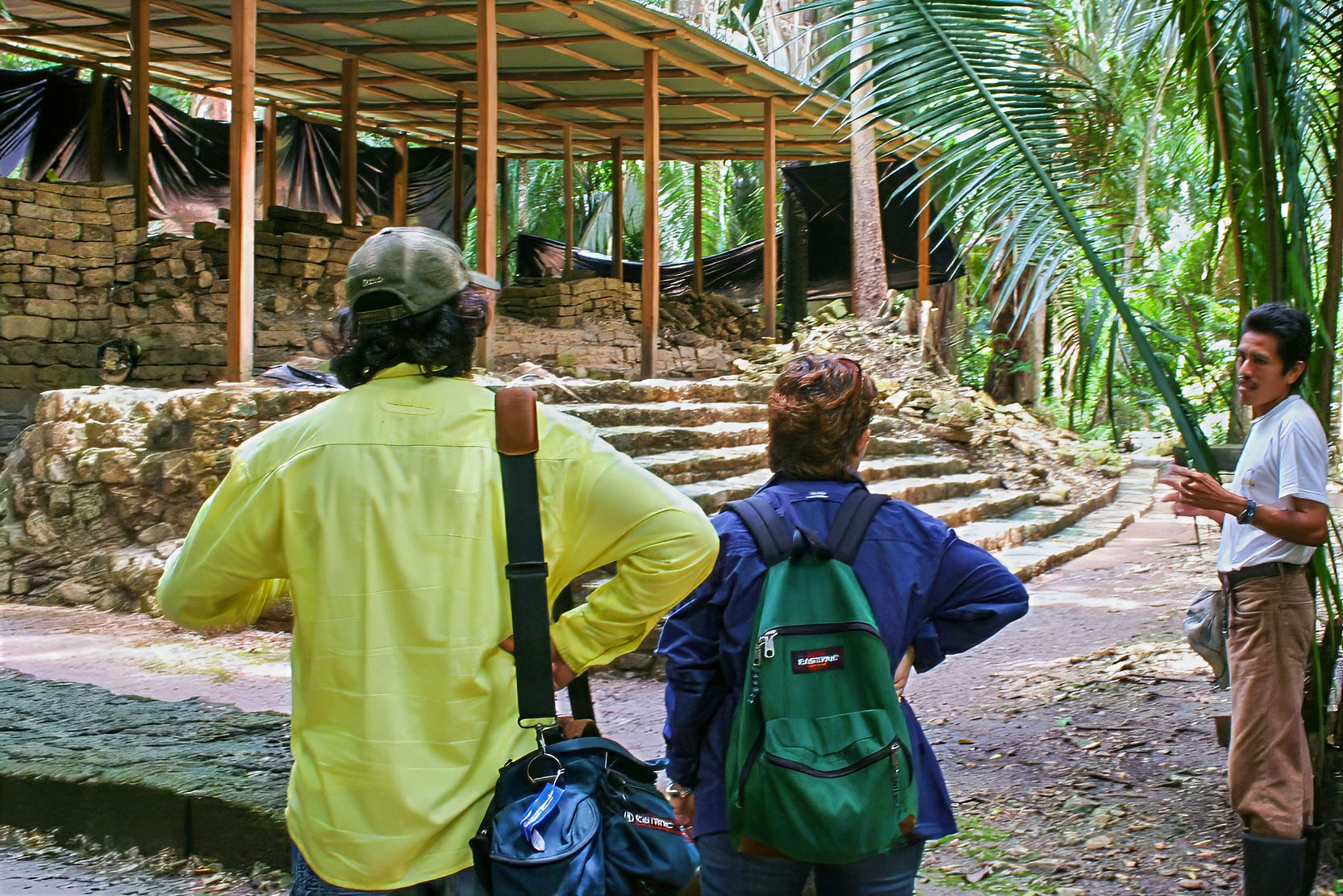 Travelers listening to a local guide sharing the history of an ancient Maya site deep within the Selva Maya during private cultural tours Guatemala experiences