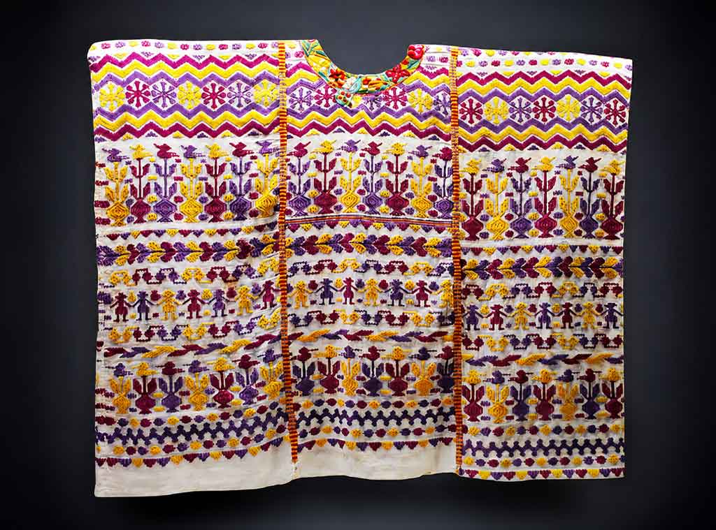 Hand-embroidered sobrehuipil from Quetzaltenango displaying geometric patterns and vibrant colors characteristic of traditional Maya clothing Guatemala.