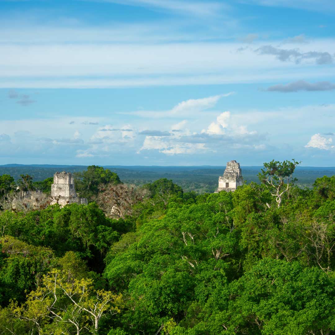 Tikal National Park: “Ancient Tikal temples rising above the tropical rainforest on Guatemala Archaeology Tours.”