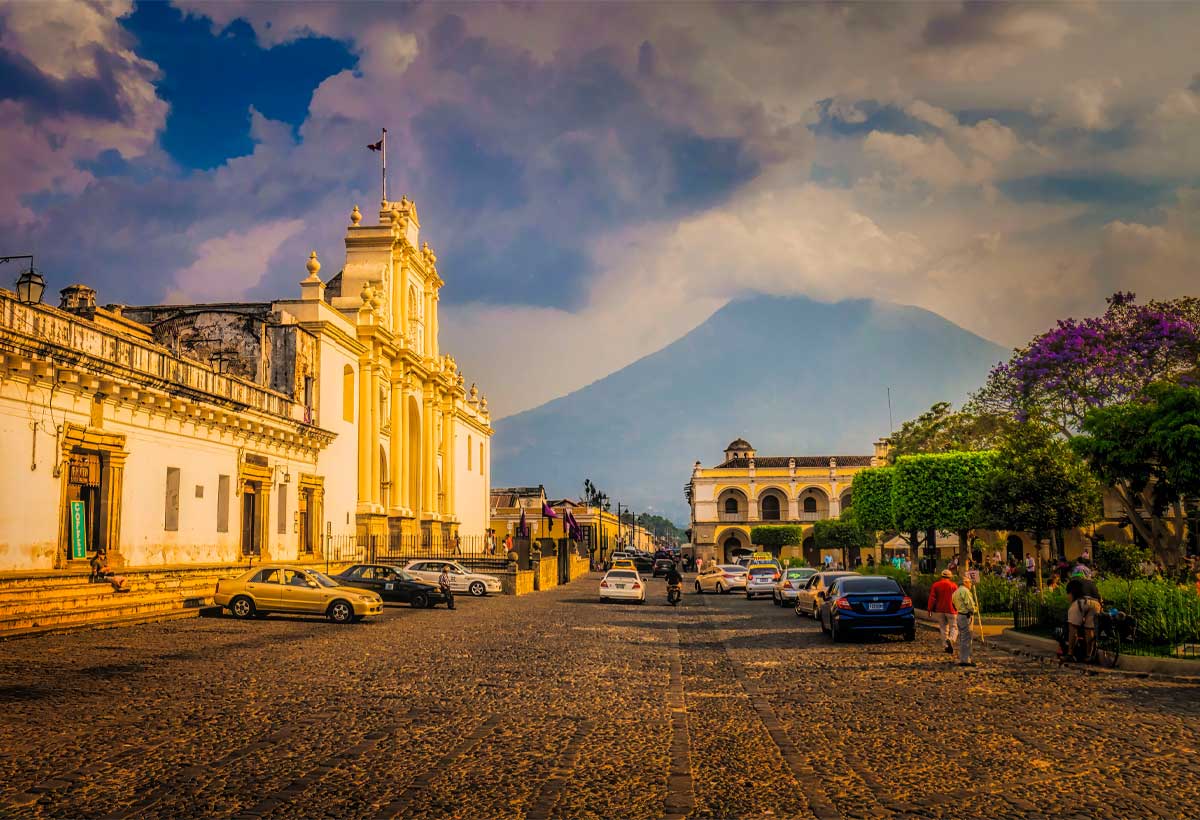 Antigua-guatemala-cathedral-and-agua-volcano | martsam travel Historic church and cobblestone street in Antigua Guatemala with Agua Volcano in the background.
