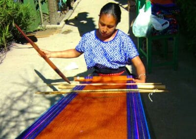 Woman weaving colorful fabric on a backstrap loom in Zinacantán during a Chiapas Cultural Tour.