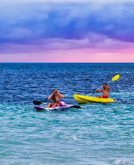 Kayaking-caribbean-belize | martsam travel Two travelers kayaking in the clear Caribbean waters of Belize.