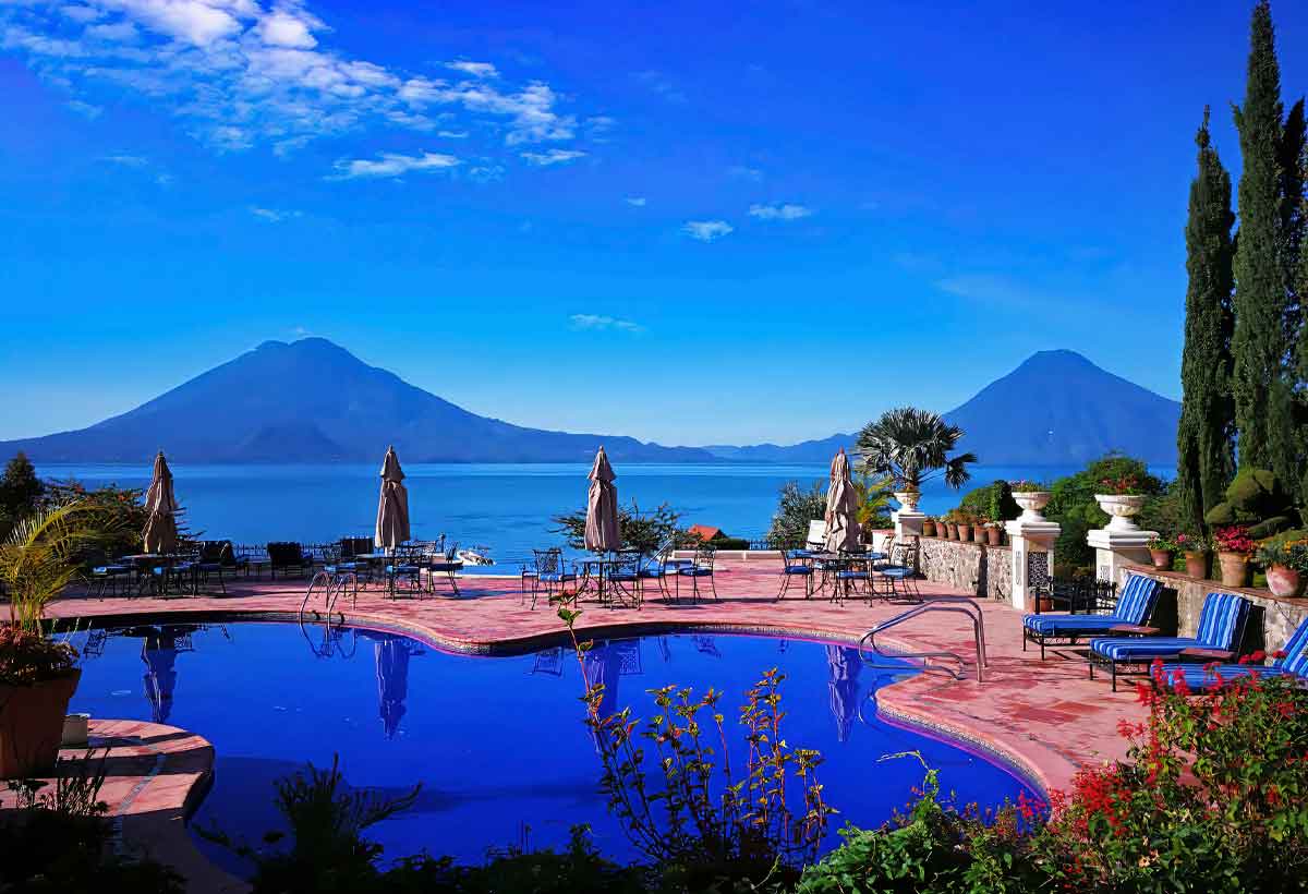 Lake-atitlan-volcano-view-guatemala | martsam travel Panoramic view of Lake Atitlán and its surrounding volcanoes from a lakeside terrace in Guatemala.