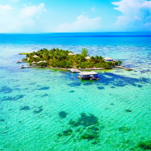 Incentive-travel-belize-private-island | martsam travel Belize corporate travel featuring a tropical private island surrounded by turquoise Caribbean waters and coral reefs.