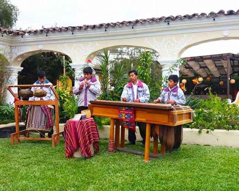 Incentive-travel-cultural-evening-celebration | martsam travel Cultural travel celebration featuring musicians and an outdoor dining setting at sunset.